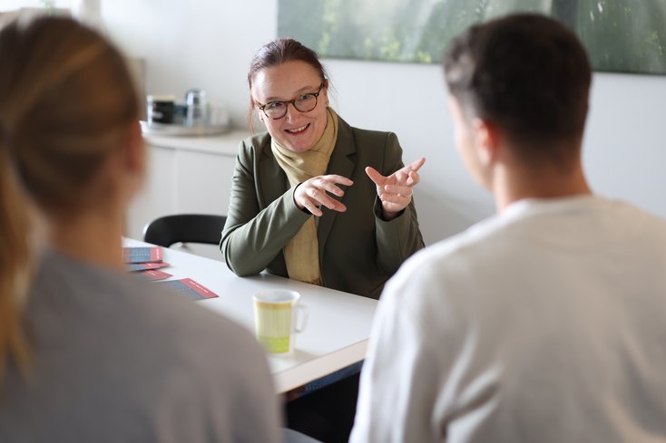 Dozentin berät zwei Studierende.