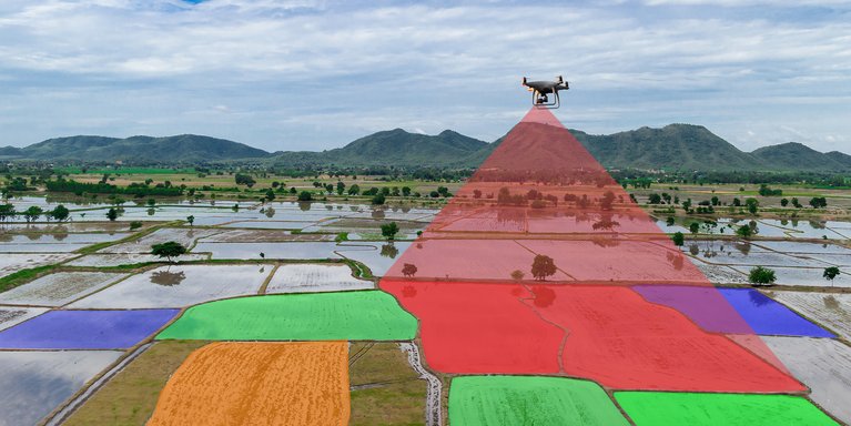 Eine Drohne vermisst Felder, die in verschiedenen Farben dargestellt sind.
