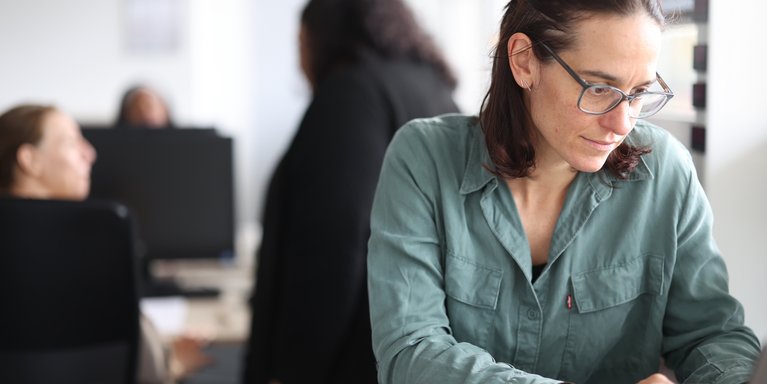 Junge Frau ist am Laptop vertieft.