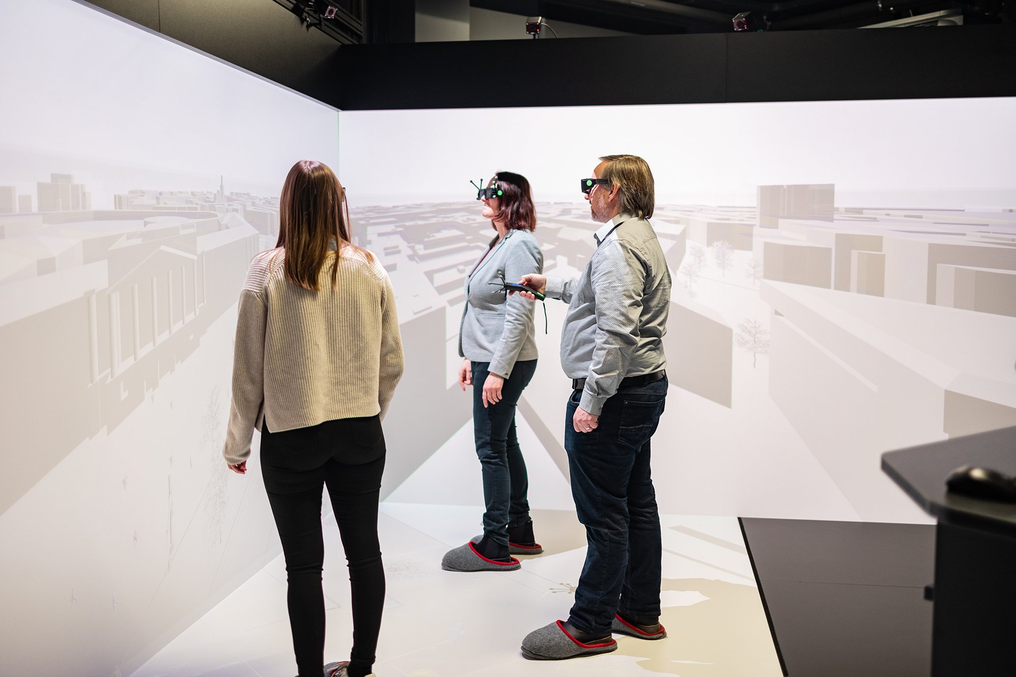 Drei Personen, die mit VR-Brillen und Kontrollern ausgestattet sind, arbeiten im Labor für digitales Engineering.