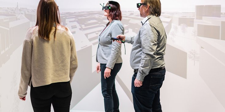 Drei Personen, die mit VR-Brillen und Kontrollern ausgestattet sind, arbeiten im Labor für digitales Engineering.