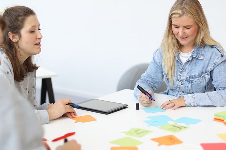 Personen schreiben auf bunte Zettel