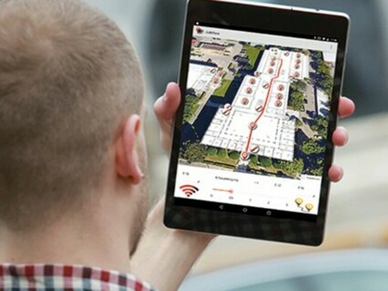 Symbolbild Geoinformatik: Student blickt auf Tablet mit Navigations-App