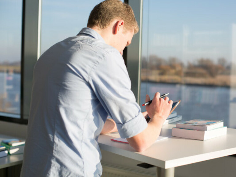 Studierender arbeitet am Campus Elsfleth mit Blick aufs Wasser