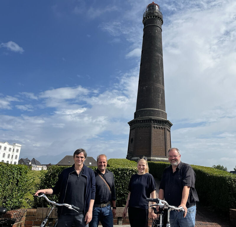 Bild von Markus Zeller, Enno Schmoll, Tamina Reinecke und Stephan Kull (v. links) vor dem Borkumer Leuchtturm 